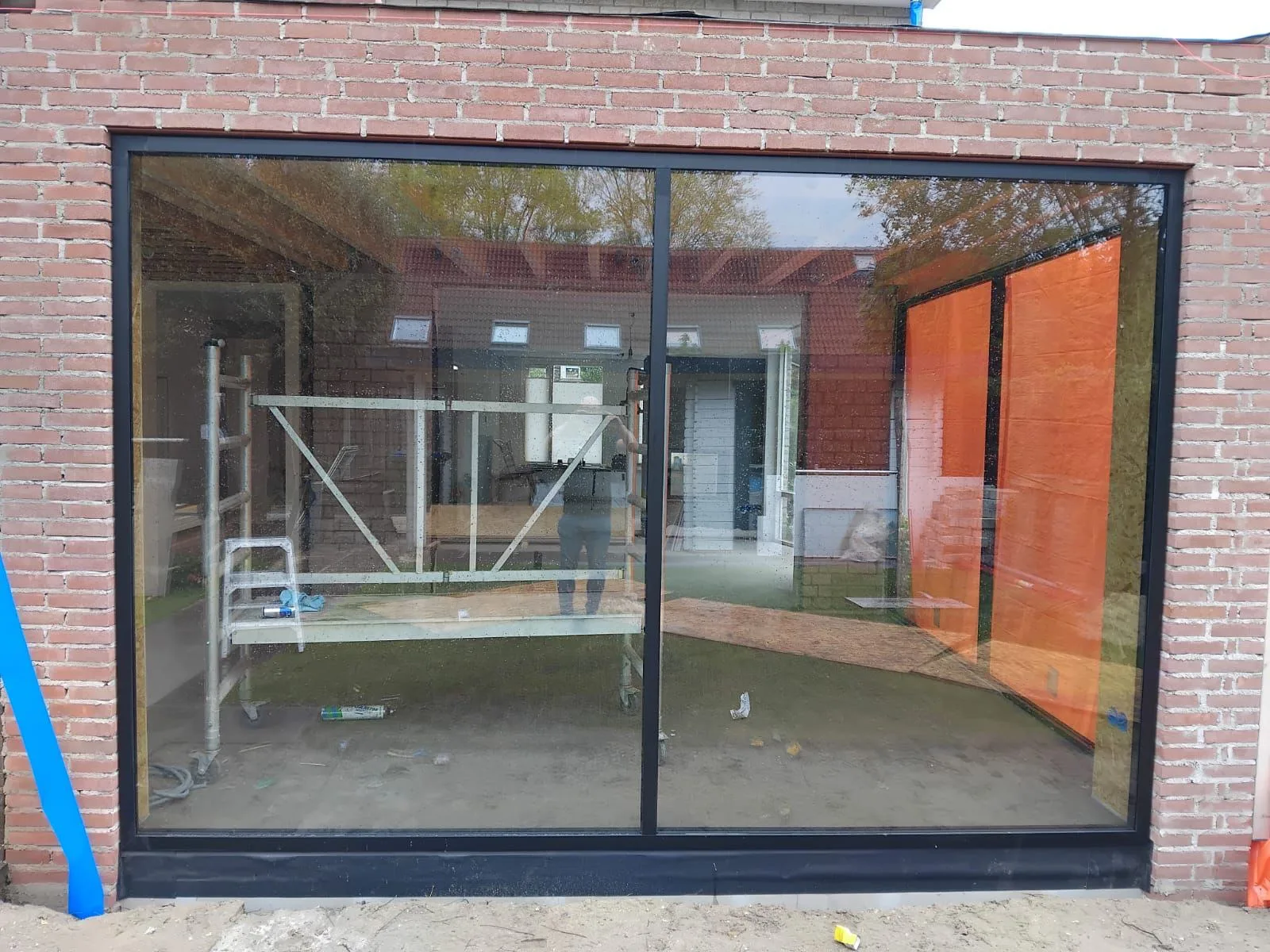 De glazen hoek van de uitbouw in Bavel tijdens de montage