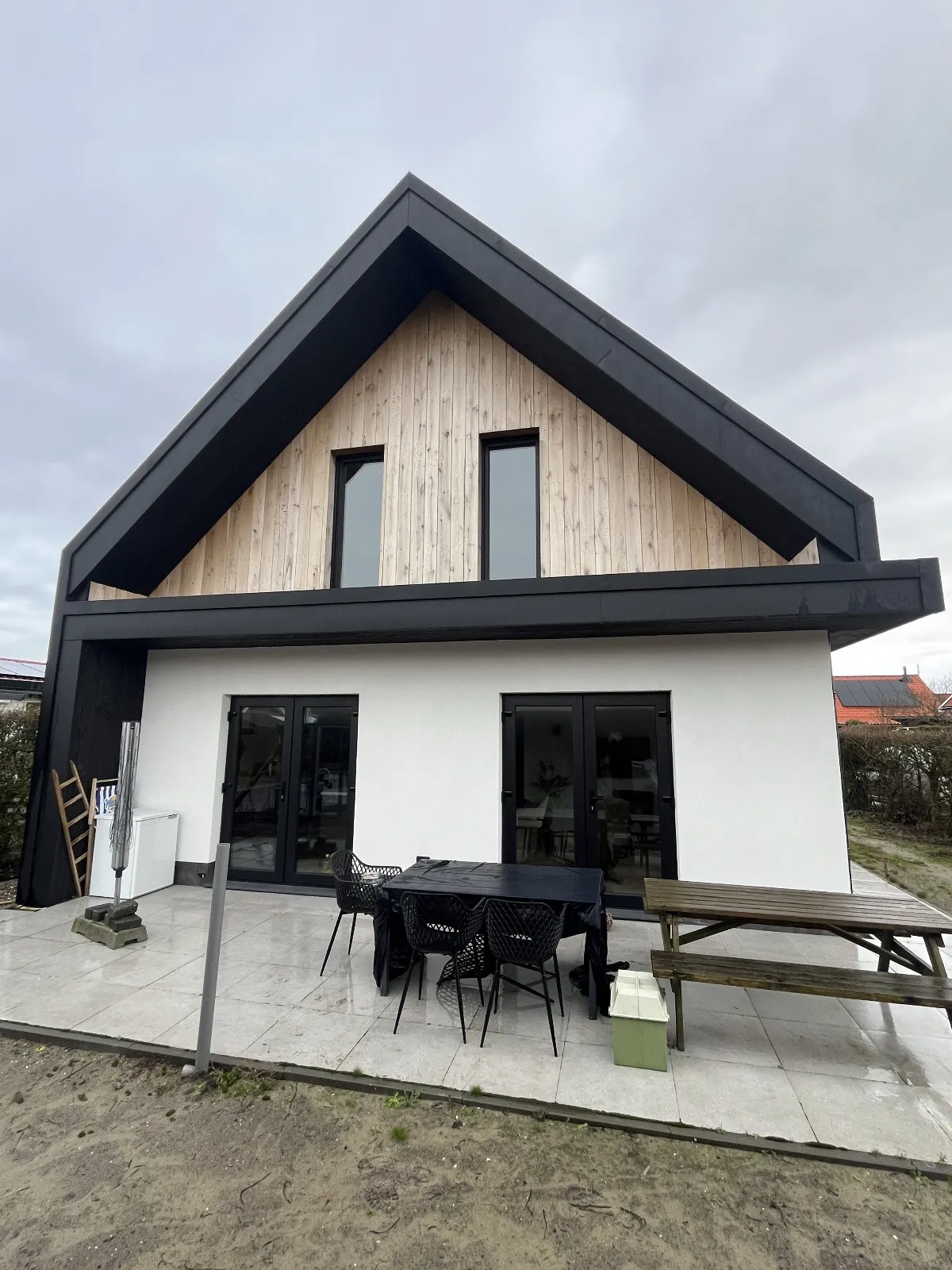 Achtergevel van een nieuwbouwwoning in Burgh-Haamstede met zwarte openslaande deuren