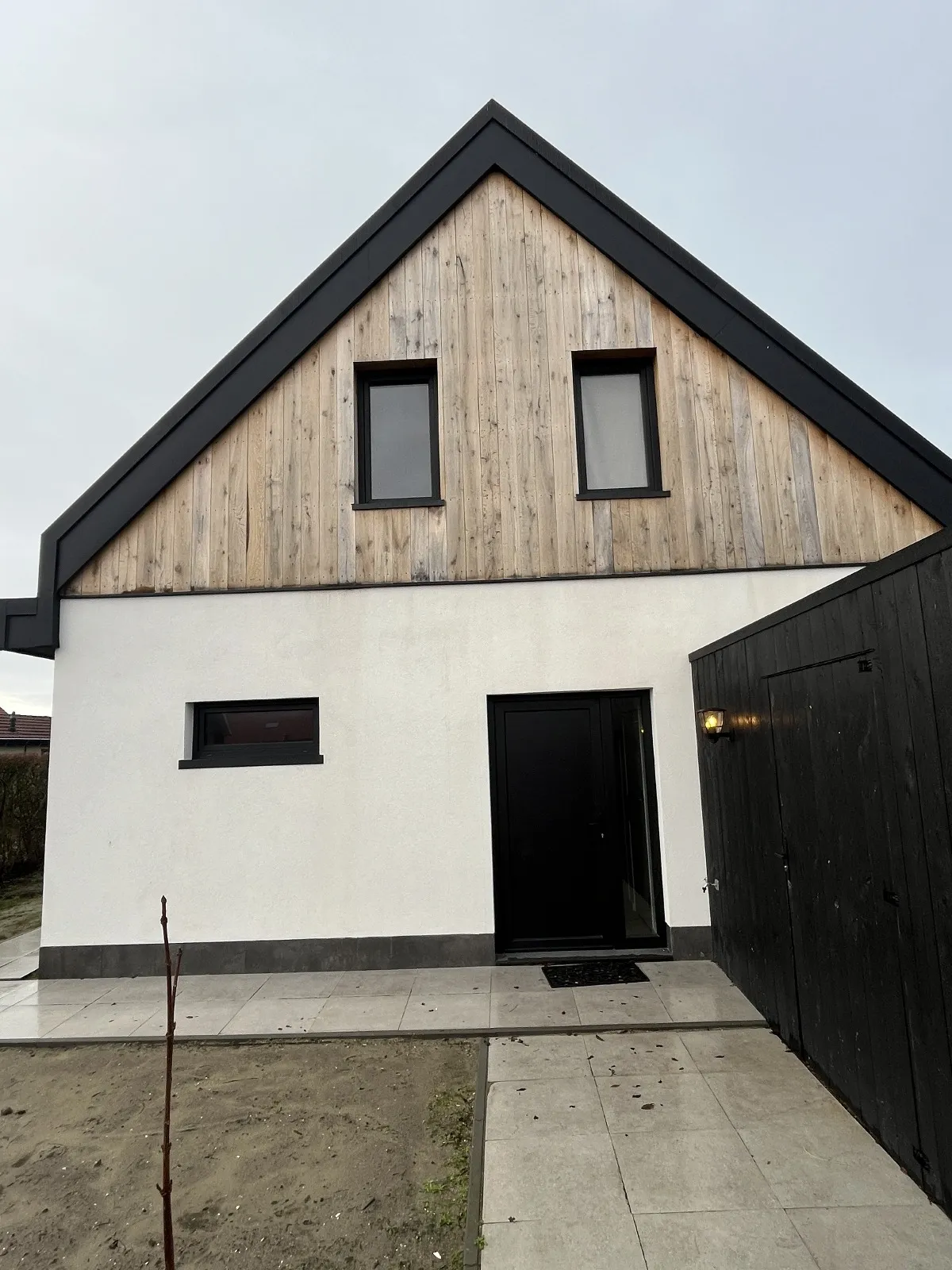 Voorgevel van een nieuwbouwwoning in Burgh-Haamstede met zwarte kozijnen en voordeur