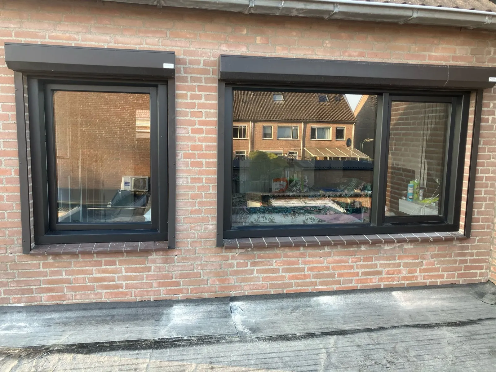 Zwarte kunststof kozijnen in een bakstenen gevel in Fijnaart
