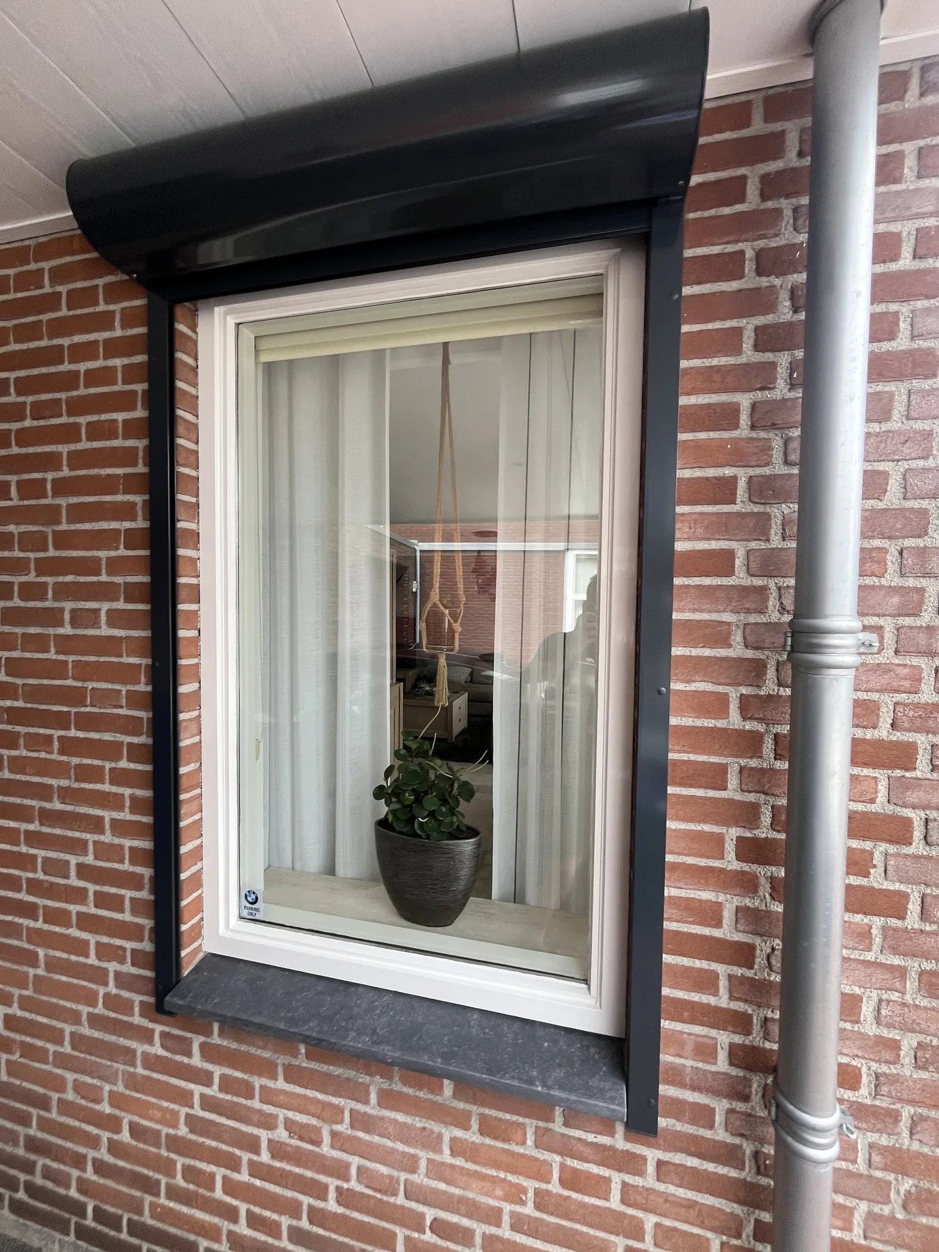 Detail van een kunststof raamkozijn met natuurstenen onderdorpel in Sprundel