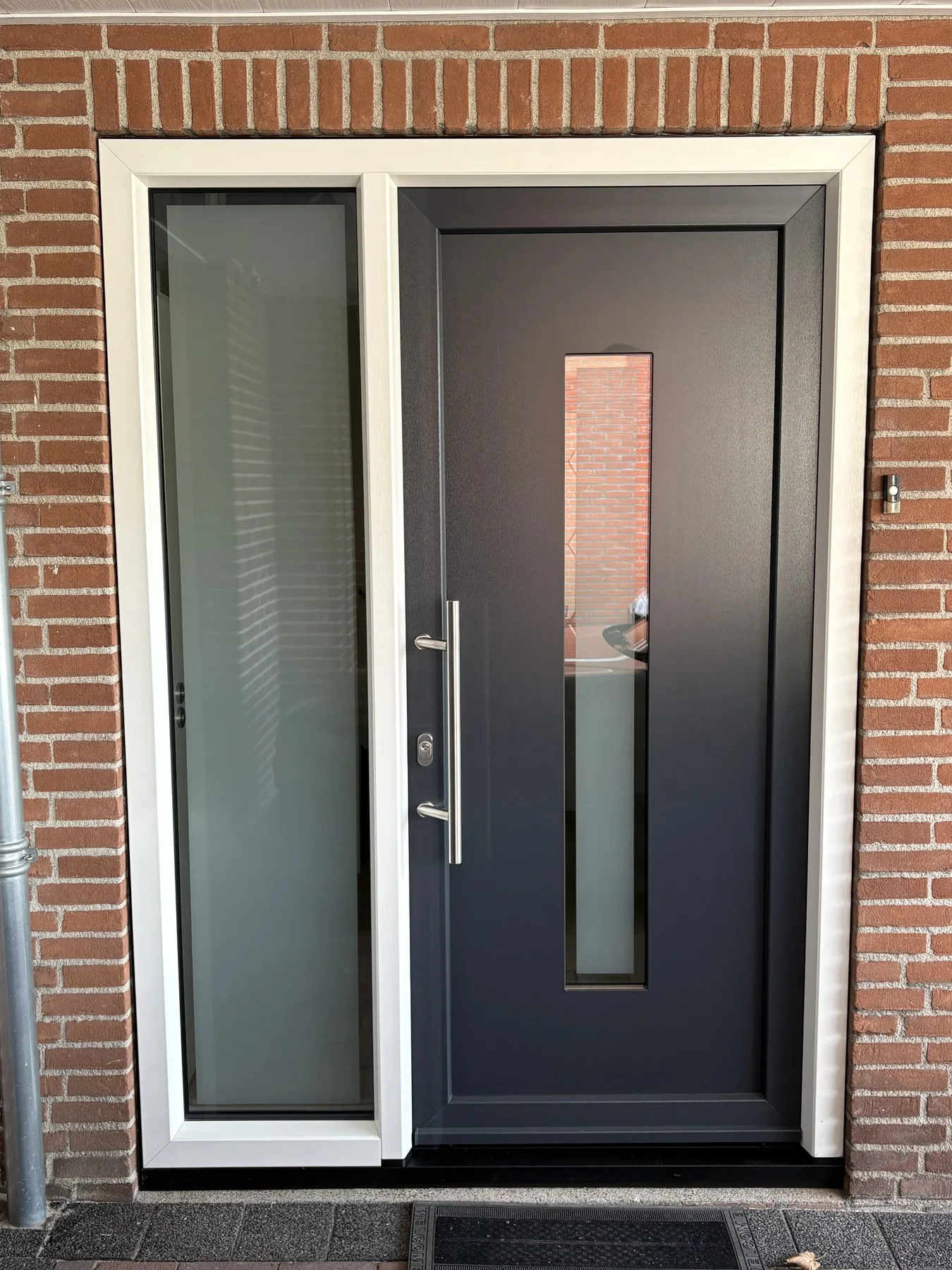 Antracieten kunststof voordeur met zijlicht en glasstrook aan de Noordereindsestraat in Sprundel
