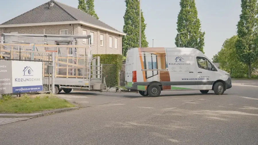 Bus met aanhanger van Kozijn Gemak, geladen met kozijnen op weg naar een project